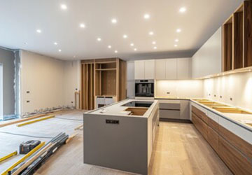 In-progress kitchen refurbishment with installed units and island, awaiting worktops and decoration